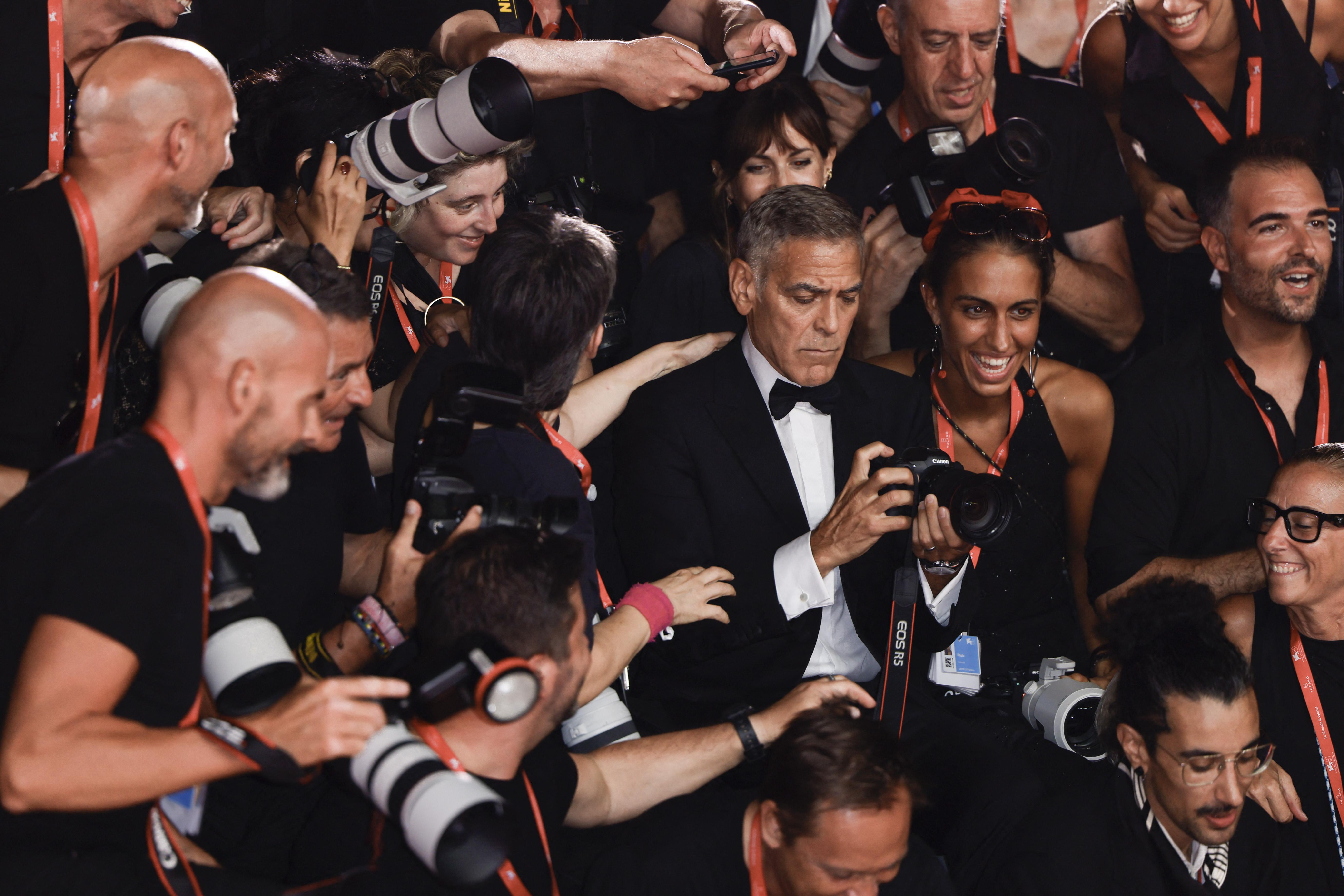 Venezia 81, George Clooney si improvvisa fotografo sul red carpet - Video